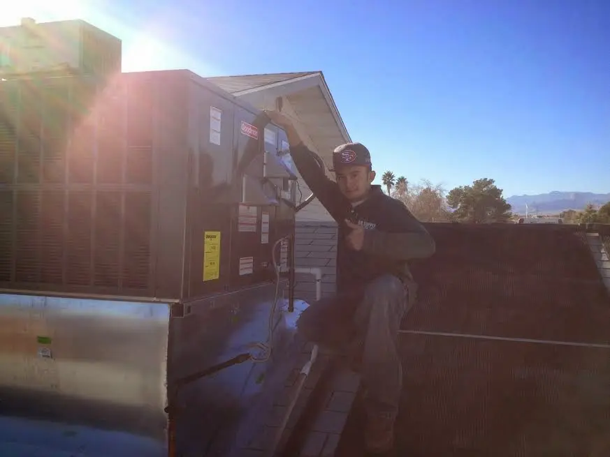 HVAC technician performing Air Duct Repair on a rooftop unit in Long Hill